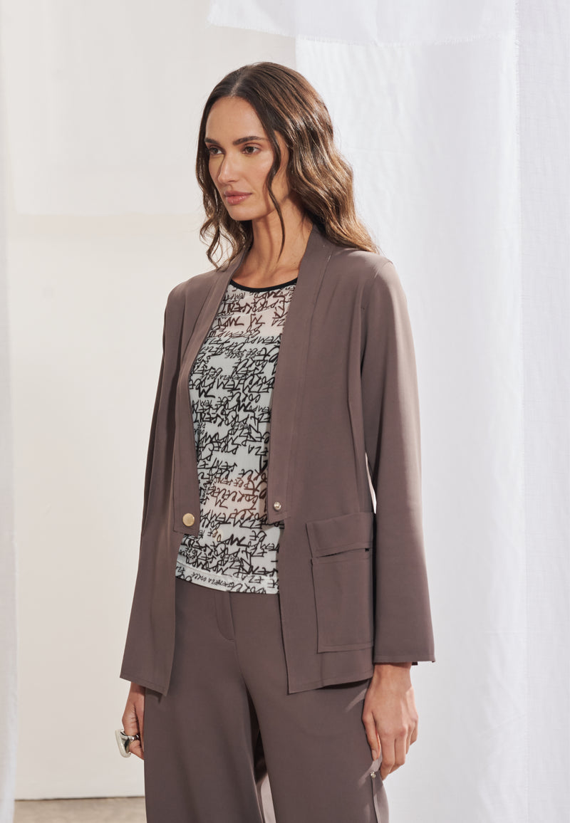 Blazer feminino alongado, com decote em V formado a partir do fechamento, ombros estruturados e mangas longas tradicionais com fendas sutis no punho. Possui nervuras que ajudam a definir a silhueta da peça e recorte assimétrico diagonal nas costas.