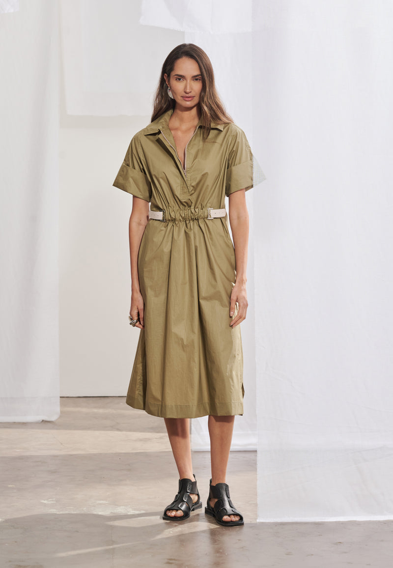 Vestido midi feminino de modelagem reta solta com mangas curtas de punho largo. Possui gola esporte, decote V com zíper tratorado aparente e ajuste na cintura regulável por cinto contrastante e fivela metálica. Saia de comprimento midi com fendas laterais e bolsos faca embutidos.