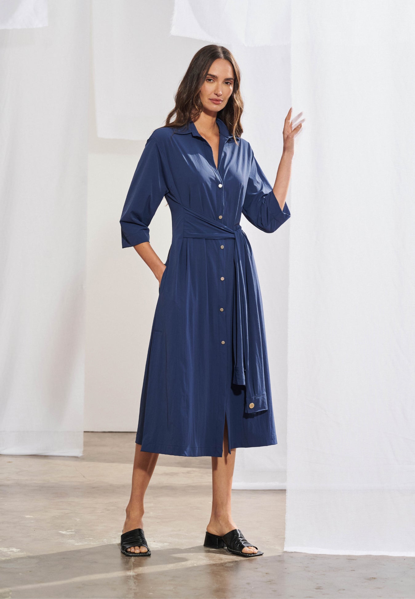 Vestido midi feminino em poliamida leve com gola estilo camisa, fechamento por botões e faixa de amarração.