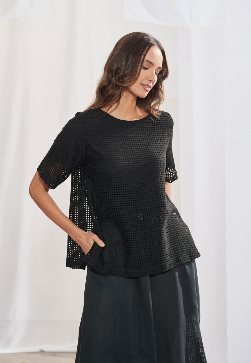 Blusa feminina ampla em malha telada com decote canoa acabado em viés. Mangas curtas com transparência visível na trama. Fendas laterais proeminentes na barra. Vista frontal mostrando a textura da tela no corpo e mangas.